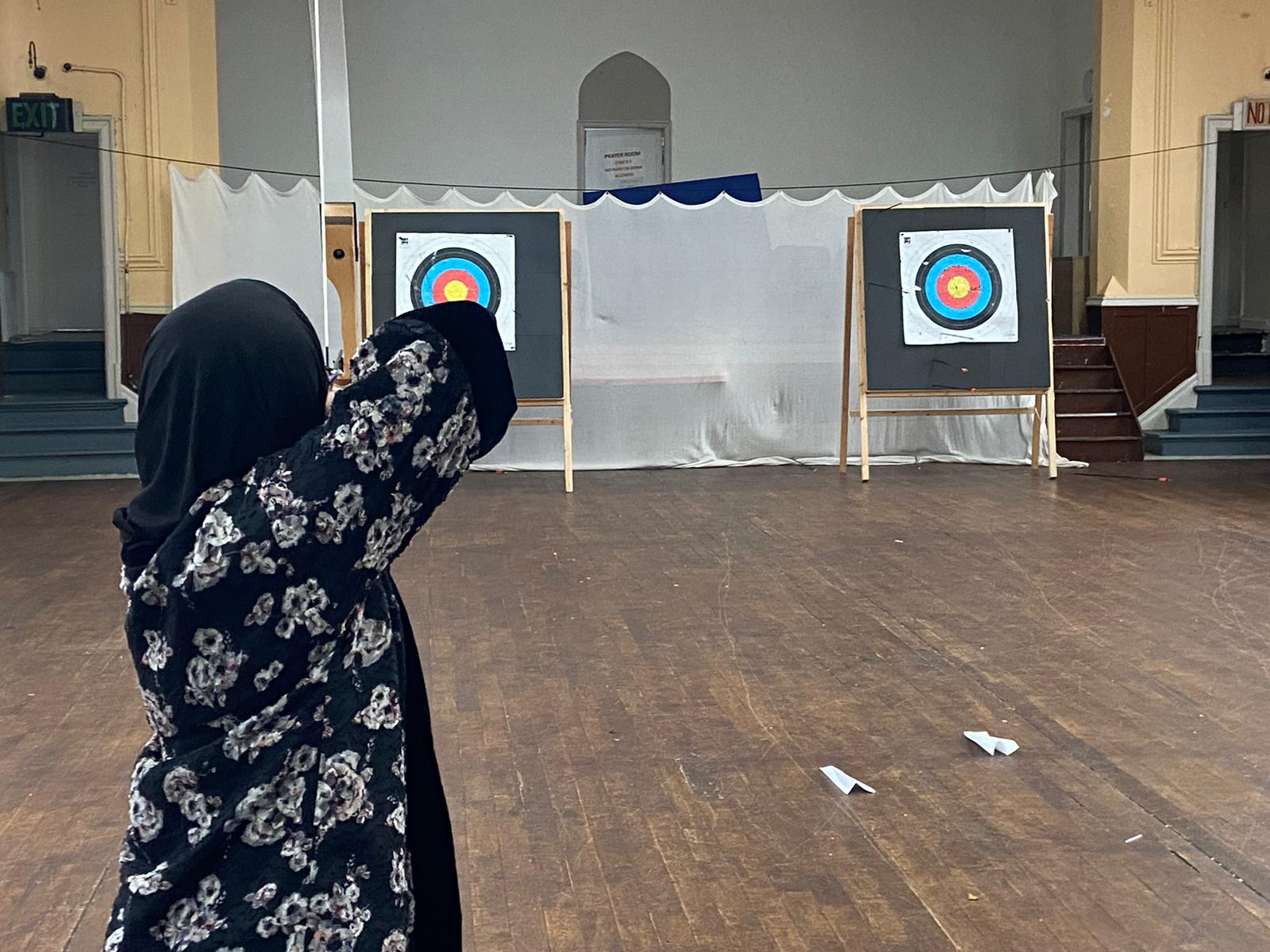 A woman shooting at an indoor archery range at KRIMMZ Rimaya Bolton 